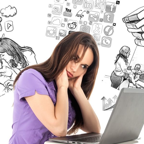 Eine Frau sitzt nachdenklich vor ihrem Laptop und um sie herum sind in Schwarz Weiß dinge gezeichnet