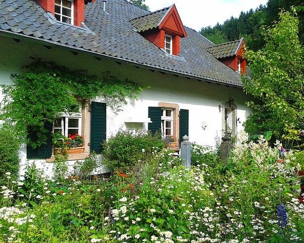 kleines Haus mit Vorgarten und Blumen