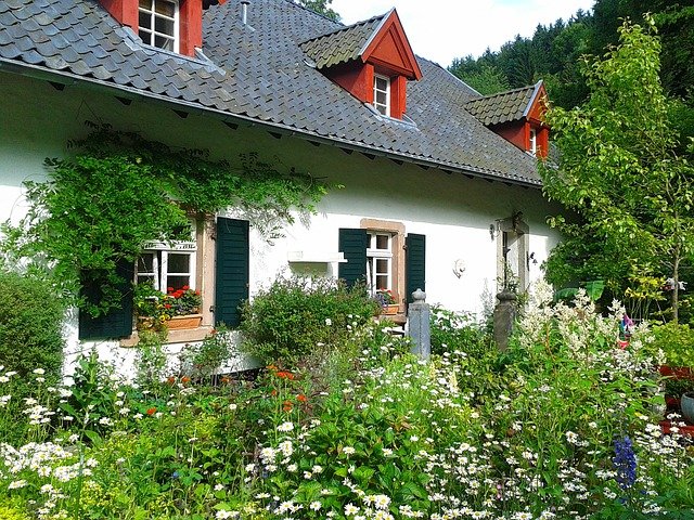 kleines Haus mit Vorgarten und Blumen